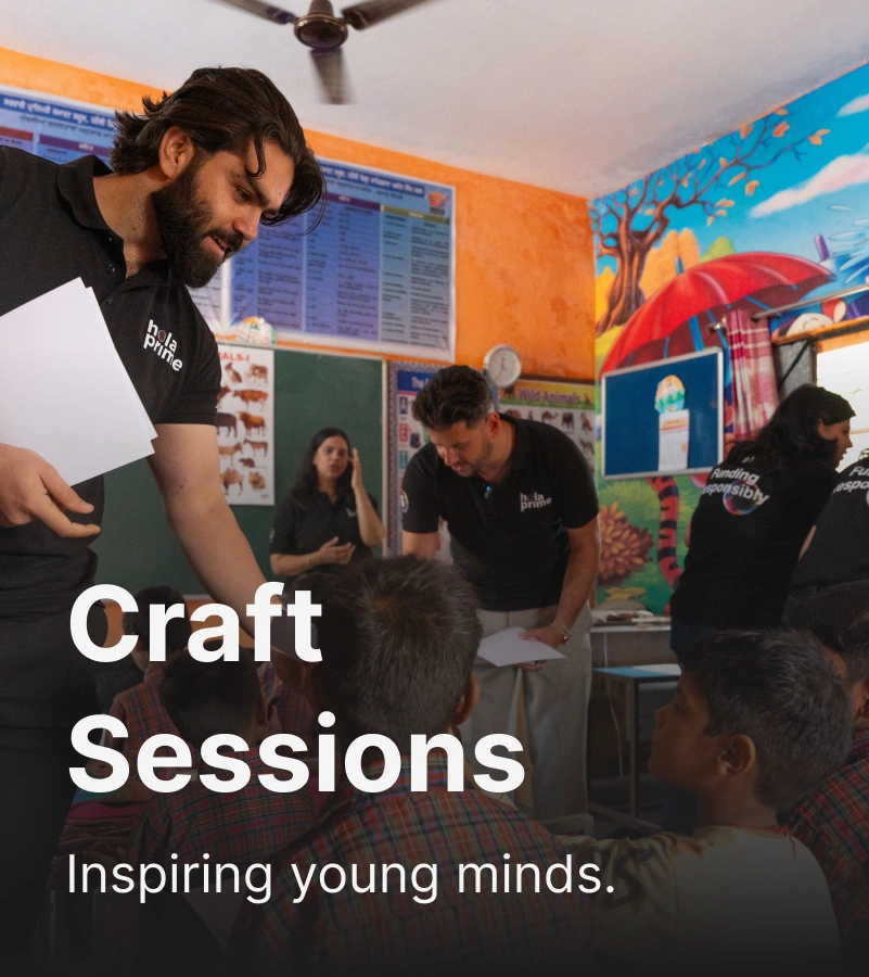 Volunteers wearing black Hola Prime T-shirts leading a craft session with young children in a colorful classroom.